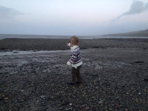 Toddler on the Beach Pointing at the Sea